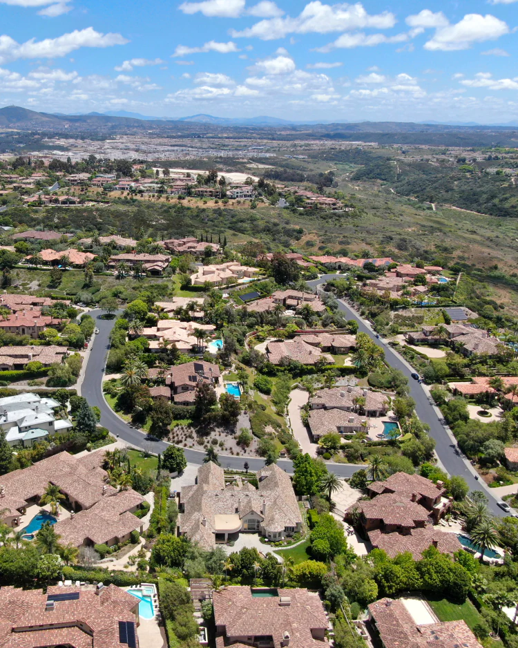 Aerial view of Pacific Highlands Ranch homes beside open canyon land in San Diego
