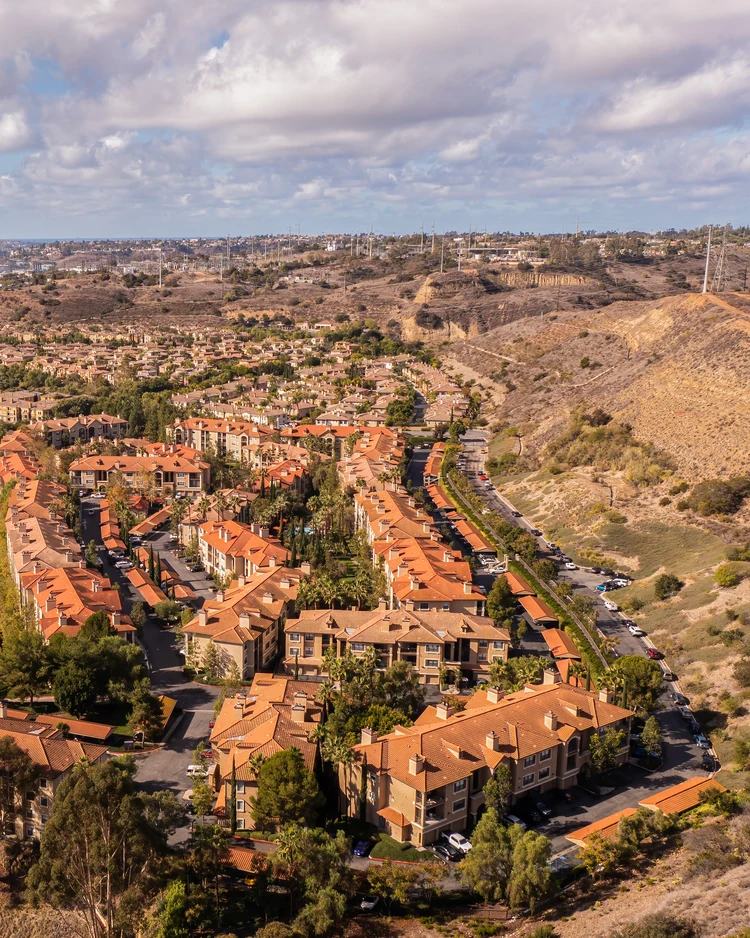 Aerial view of a multi-unit residential community beside Mission Valley hills