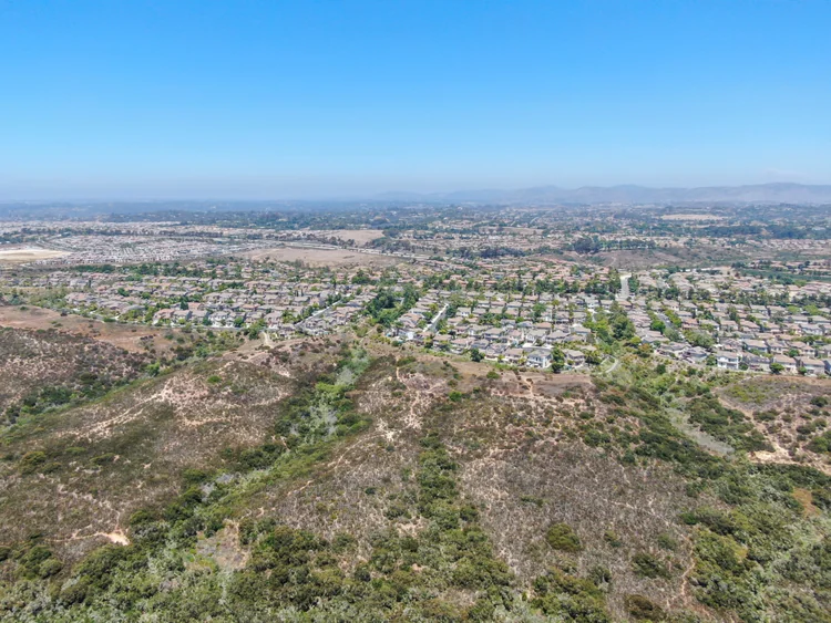 San Diego County homes beside an open canyon and hillside.