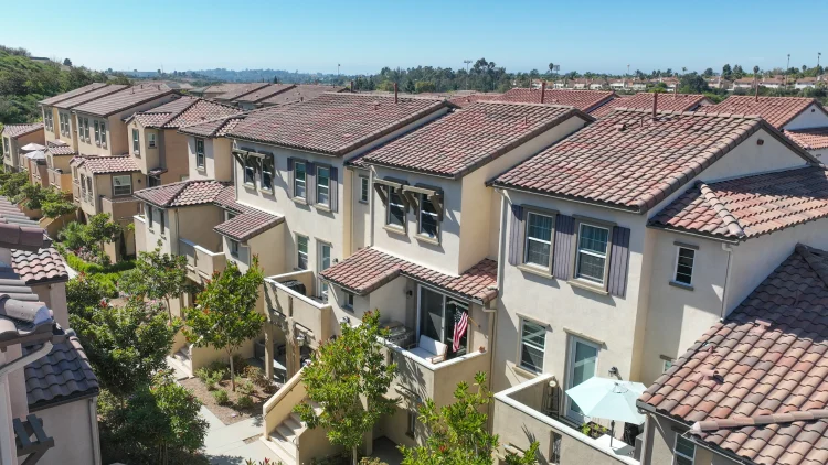 Attached homes with tile roofs and landscaped walkways in a Southern California community